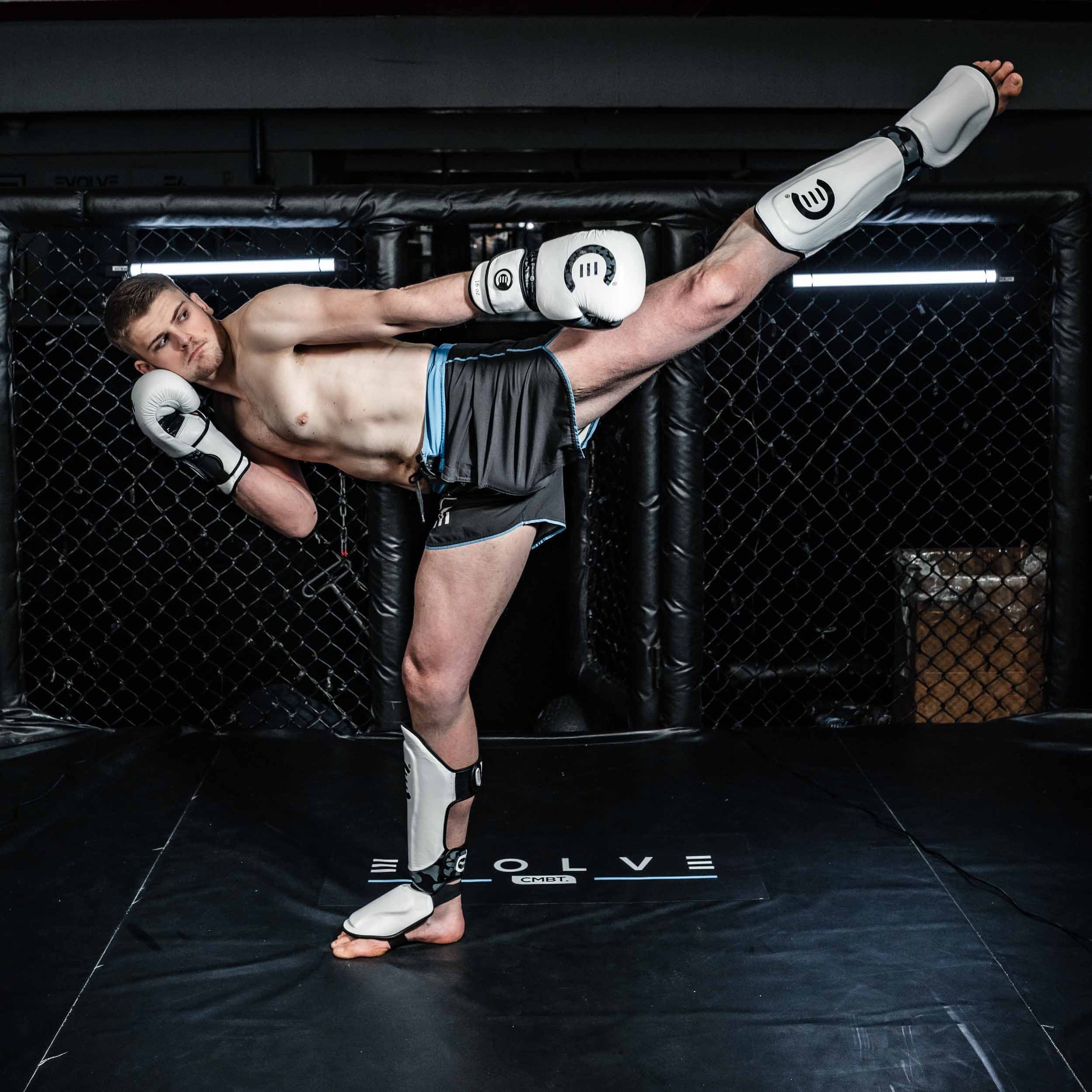 Evolve Combat — høyt spark med hvitt utstyr i buret